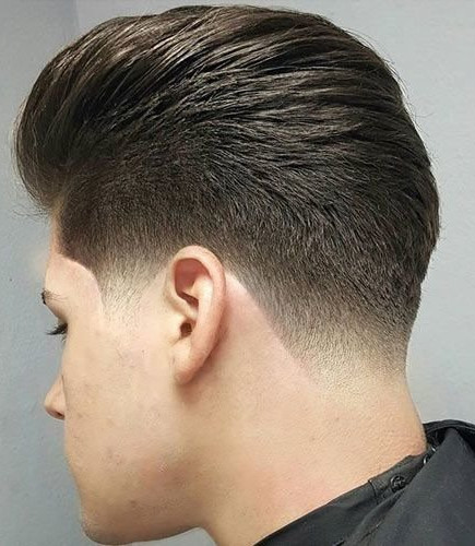 A young man with a taper fade haircut, featuring gradual blending on the sides and back for a clean modern look.